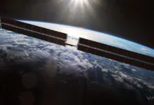 Satellite with solar panels orbiting Earth, sun shining above.