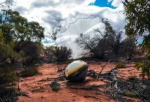 Varda W-3 capsule with parachute landed in a desert landscape.
