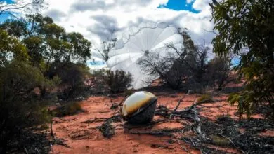 Varda W-3 capsule with parachute landed in a desert landscape.