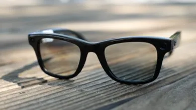 Black Ray-Ban Meta smart glasses on a weathered wooden surface.
