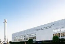 SpaceX headquarters with a rocket replica in front of the building.