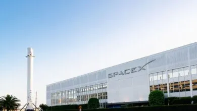 SpaceX headquarters with a rocket replica in front of the building.