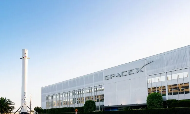 SpaceX headquarters with a rocket replica in front of the building.