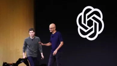 Greg Brockman and Satya Nadella on stage with OpenAI logo.