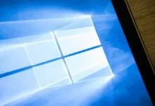 Windows logo on a blue screen, partially visible on a wooden surface.