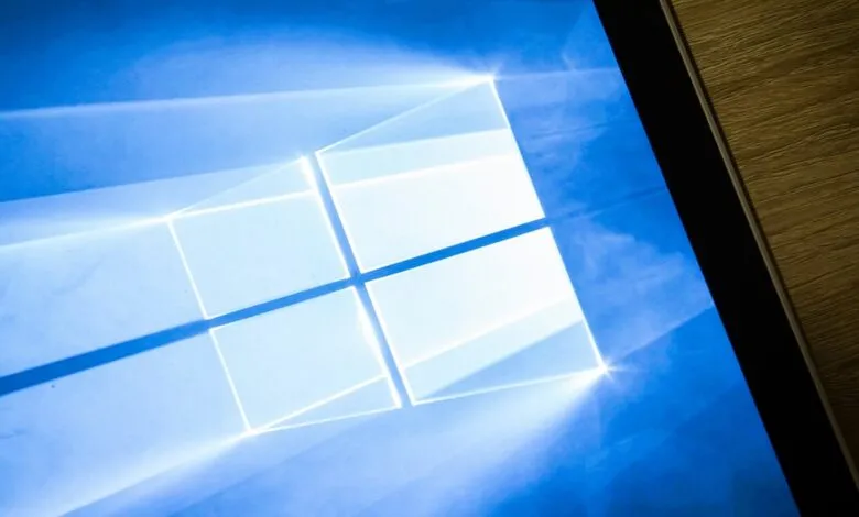 Windows logo on a blue screen, partially visible on a wooden surface.