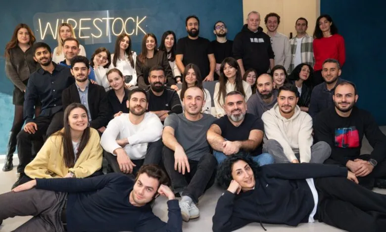 Group photo of Wirestock team members smiling and posing together indoors.