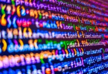 Abstract view of colorful computer code on a dark screen.