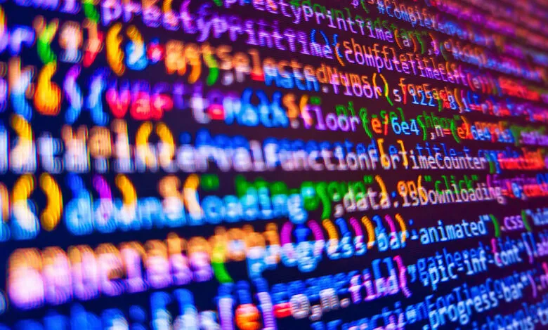 Abstract view of colorful computer code on a dark screen.