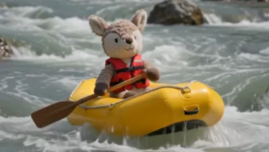 Stuffed deer toy in a yellow raft on a rushing river.