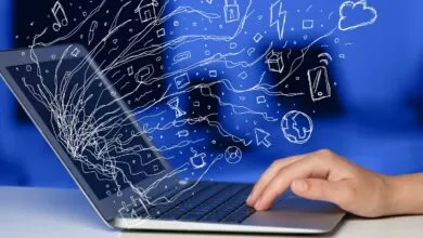 Laptop with hand typing, digital icons floating from the screen.