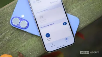 Two smartphones showing file sharing interface on a wooden surface.