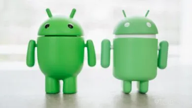 Two green Android robot figurines stand side-by-side.