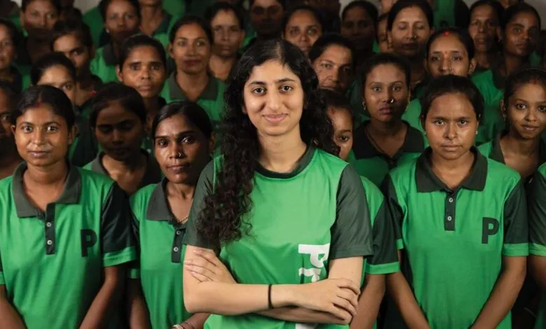 Group of women in green shirts, one with arms crossed in front.