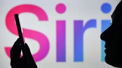 Silhouette of person using phone with 'Siri' logo in background.