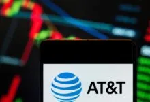 AT&T logo displayed on a smartphone screen with stock chart background.