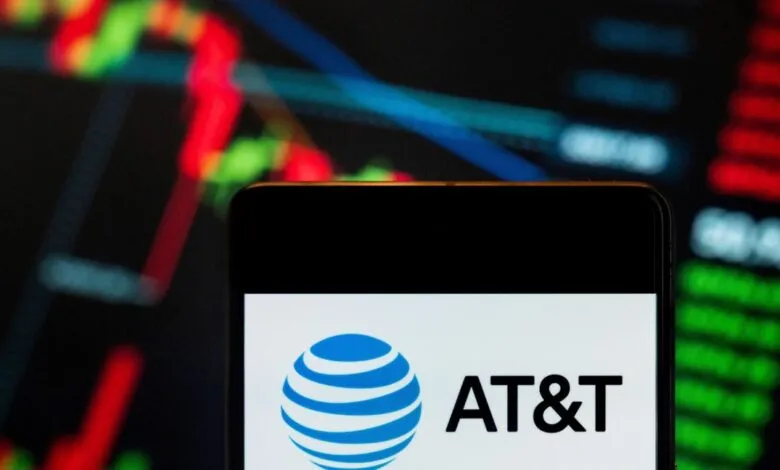 AT&T logo displayed on a smartphone screen with stock chart background.