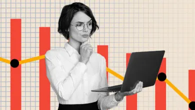 Woman with laptop looks thoughtfully at a declining financial graph.