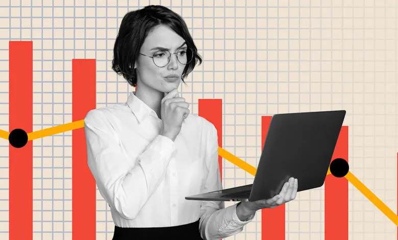 Woman with laptop looks thoughtfully at a declining financial graph.