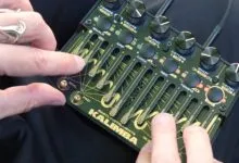 Hands play Bastl Instruments Kalimba, a unique electronic musical instrument.