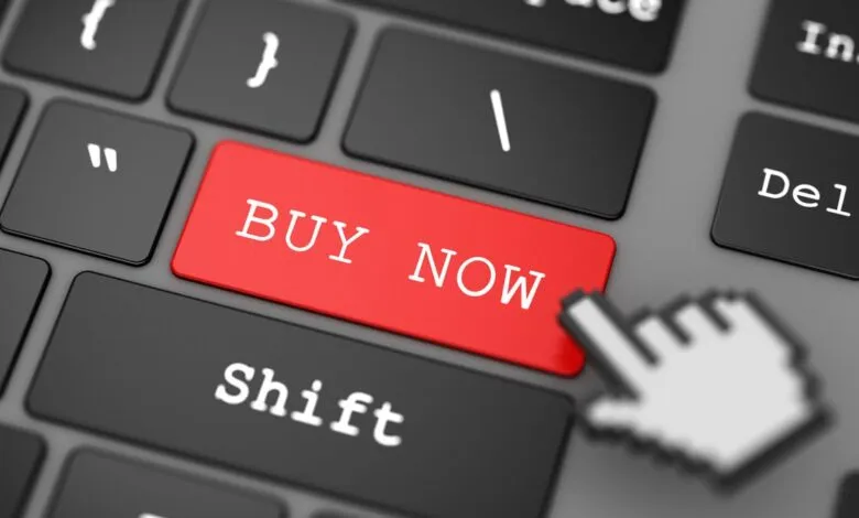 Close-up of a keyboard with a red 'Buy Now' key and mouse cursor.