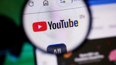 Magnifying glass over YouTube logo on a computer screen.