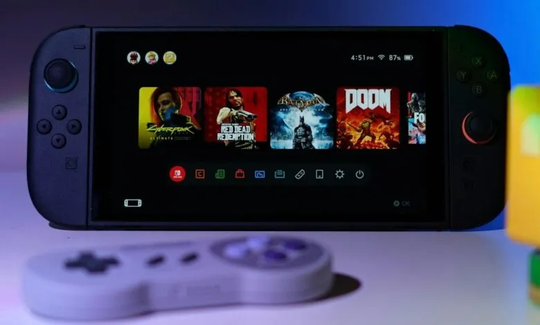 Handheld gaming console displaying game selection screen with controller.