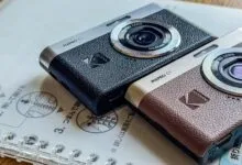 Two Kodak PIXPRO C1 cameras, one black and one brown, on a notebook.
