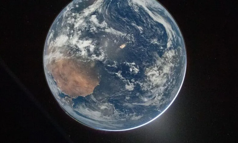 View of Earth from space showing continents, oceans, and cloud cover.