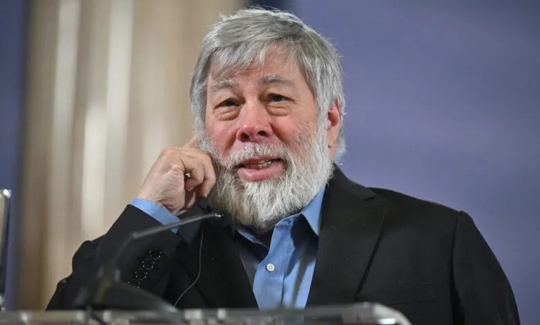 Steve Wozniak smiles slightly, wearing a suit and light blue shirt.