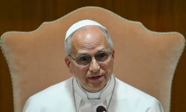 Archbishop Claudio Gugerotti speaking at a microphone, wearing glasses.
