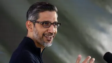 Sundar Pichai, CEO of Google, smiles while speaking into a microphone.