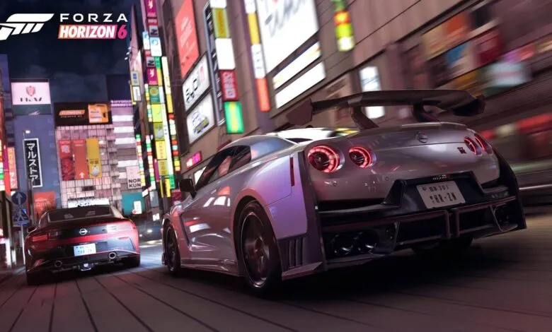 Forza Horizon 6 game scene shows two cars racing through a neon-lit city at night.