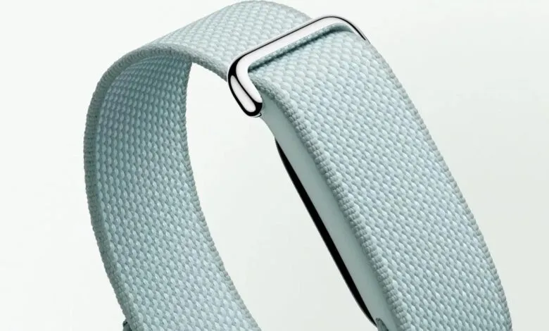Close-up of a light blue woven Fitbit band with a silver buckle.