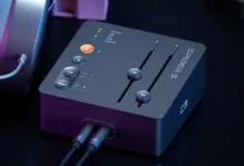 Fosi Audio Spider S3 audio interface with headphones, dark background.