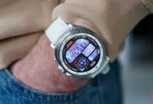Close-up of a smartwatch with a white band on a person's wrist.