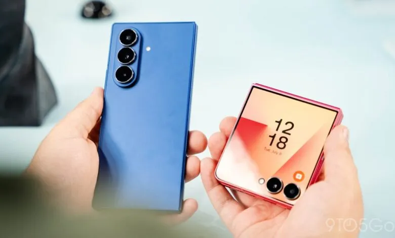 Hands holding a blue smartphone and a pink flip phone with date displayed.