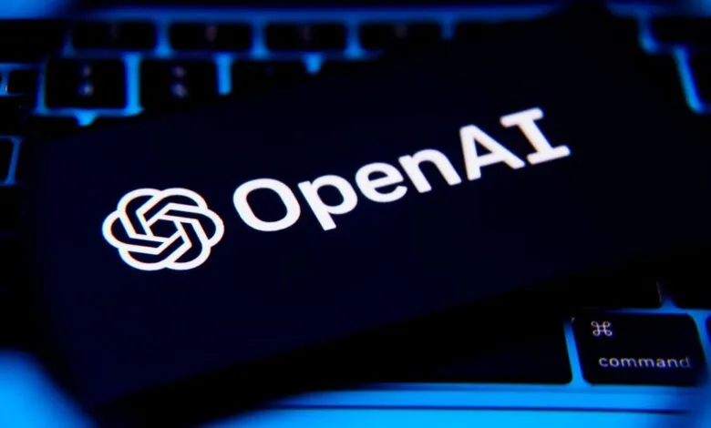 OpenAI logo and text displayed on a dark screen atop a laptop keyboard.