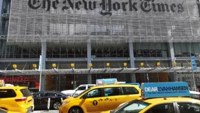 New York Times building with yellow taxis in foreground.