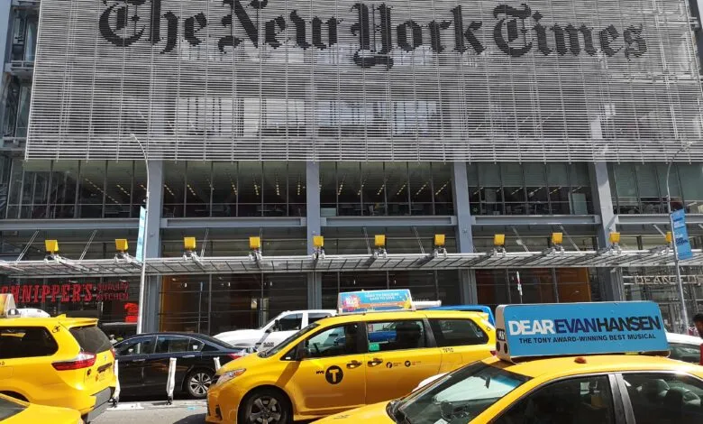 New York Times building with yellow taxis in foreground.