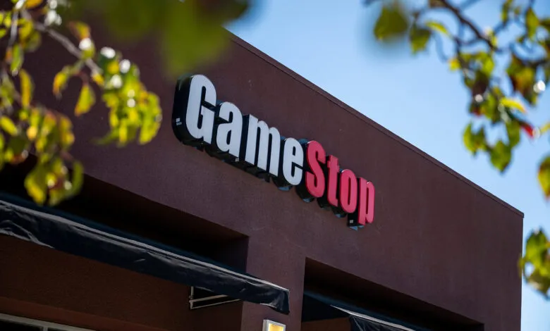 GameStop store exterior with white and red logo against a brown building.