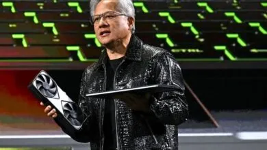 Jensen Huang presents NVIDIA GPU and laptop on stage.