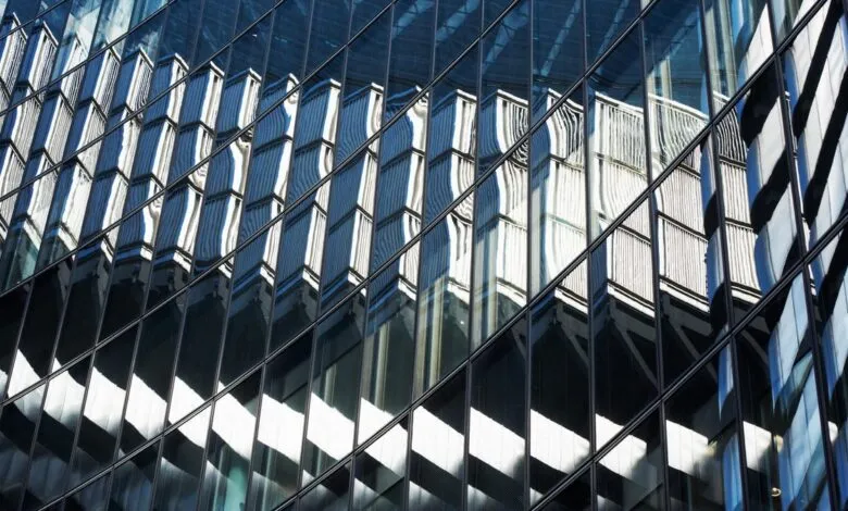 Abstract view of a glass building reflecting another structure.