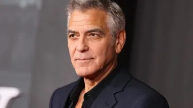 Close-up of George Clooney in a dark suit against a gray backdrop.
