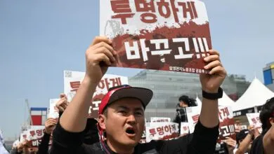 Protester holds sign in Korean at rally, demanding transparency.