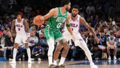 Basketball action shot: Jayson Tatum dribbles against Paul George.