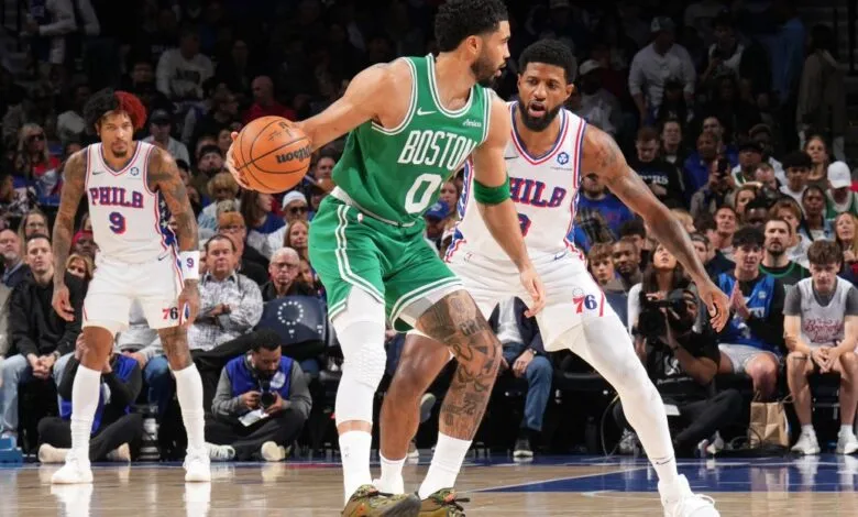 Basketball action shot: Jayson Tatum dribbles against Paul George.