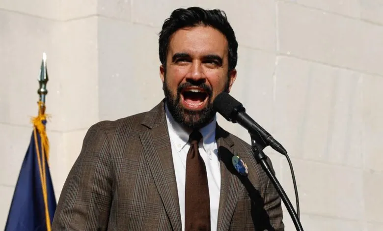 Man in suit speaks passionately at microphone, outdoors.