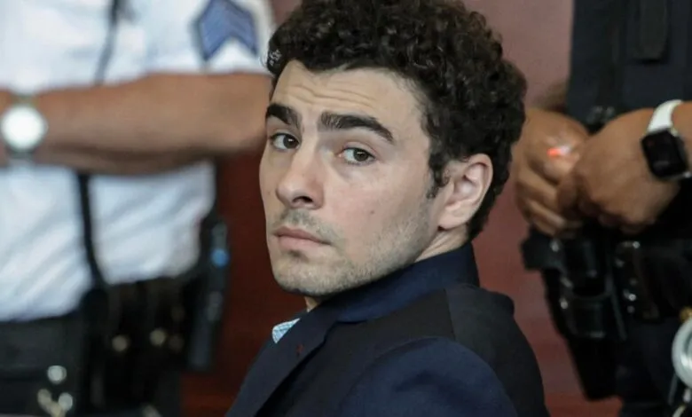 Man with curly hair looks over shoulder, surrounded by law enforcement.