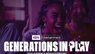 Three young adults react with excitement while looking at a screen.